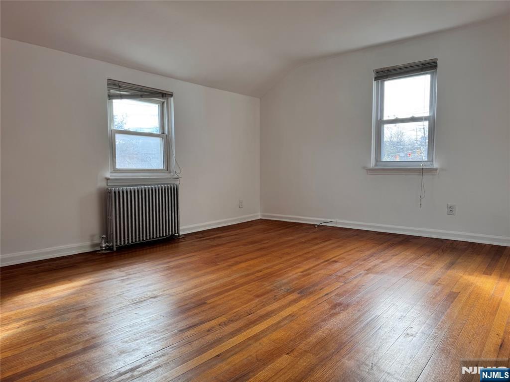 567 Boulevard, Unit 2 Hasbrouck Heights, NJ 07604 - Photo 2 of 7 an empty room with wooden floor and windows