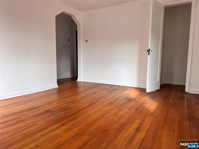an empty room with wooden floor and entrance
