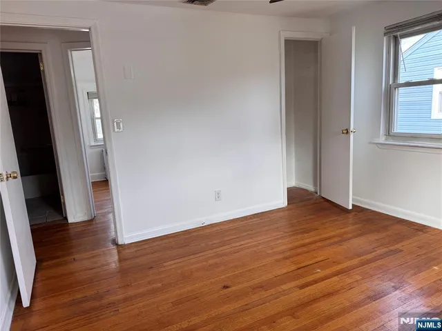 an empty room with wooden floor and a window