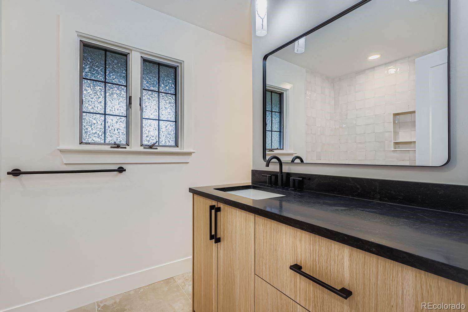 2127 Elderberry Road Golden, CO 80401 - Photo 24 of 43 a bathroom with a granite countertop sink and a mirror