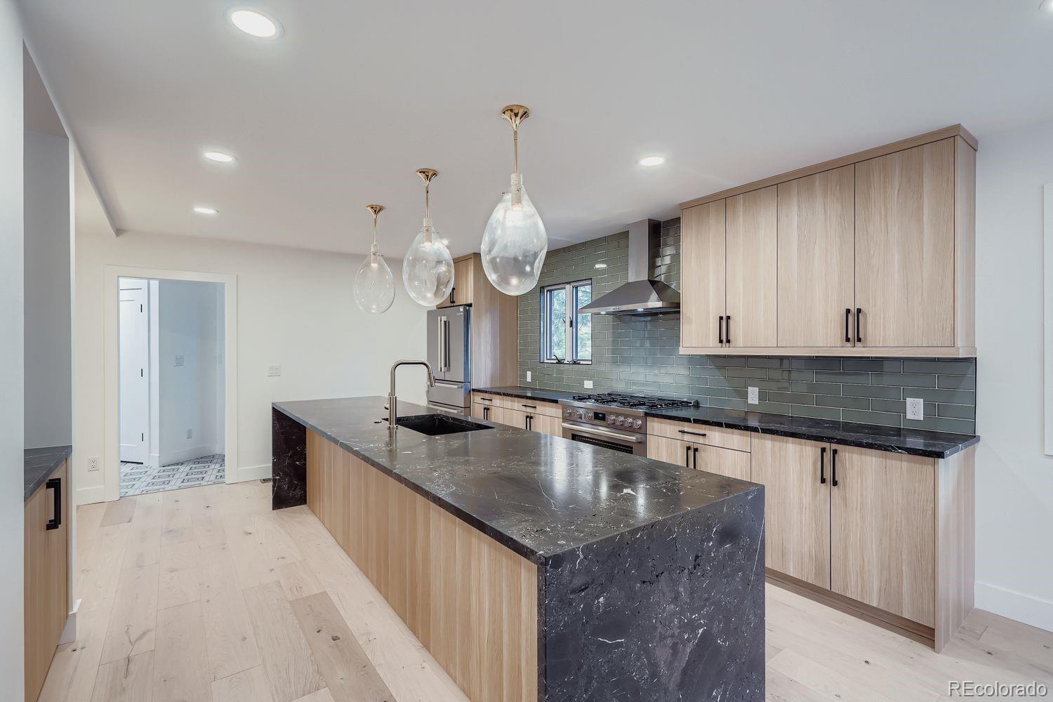 2127 Elderberry Road Golden, CO 80401 - Photo 7 of 43 a kitchen with stainless steel appliances granite countertop a sink a stove and a wooden cabinets