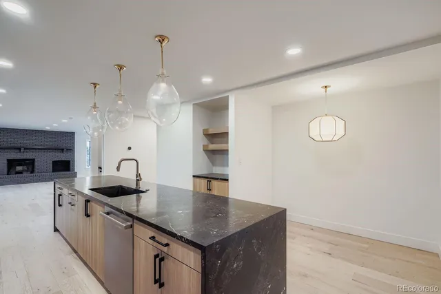 a kitchen with granite countertop a sink a counter top space and cabinets