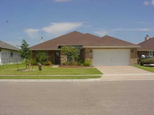 a front view of a house with a yard and trees