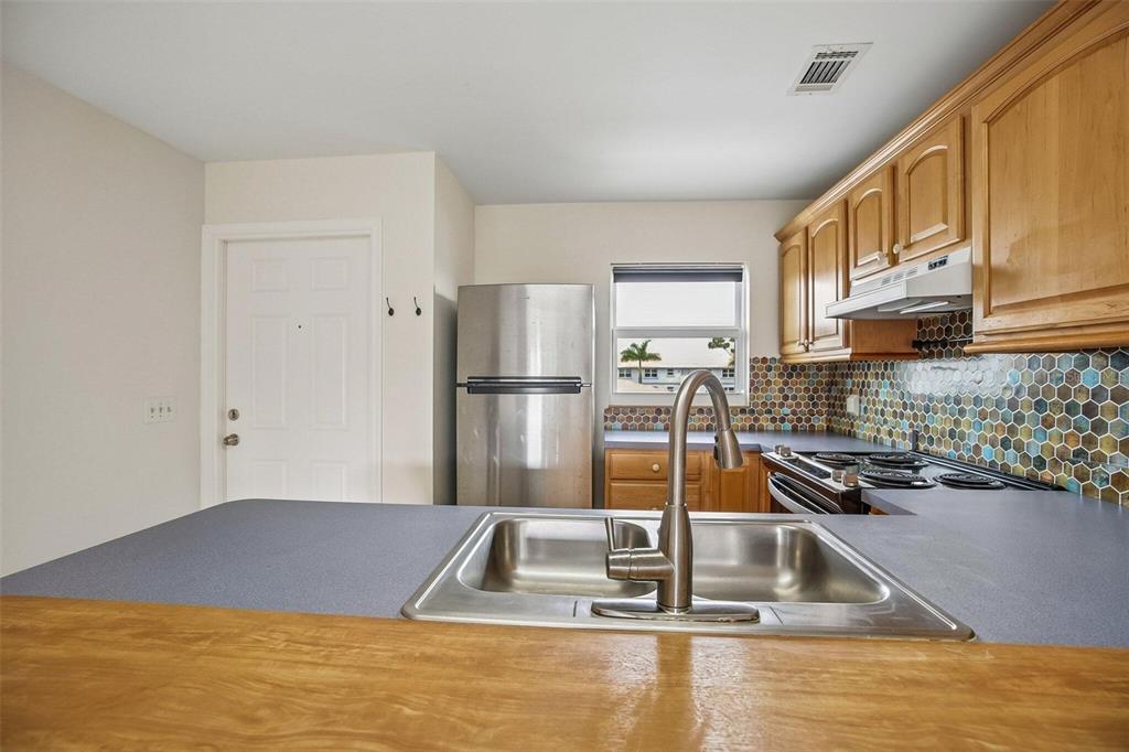 26485 Rampart Boulevard, Unit A27 Punta Gorda, FL 33983 - Photo 11 of 27 a kitchen with a refrigerator a sink and a stove