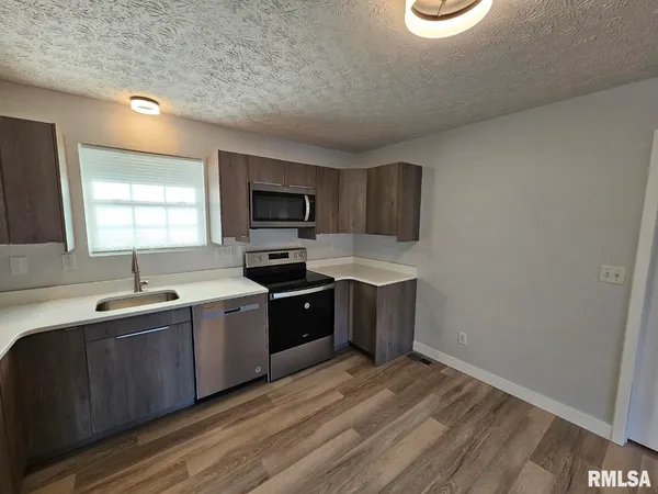 a kitchen with a sink cabinets and window