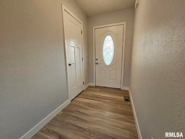 a view of a room with wooden floor and white wall