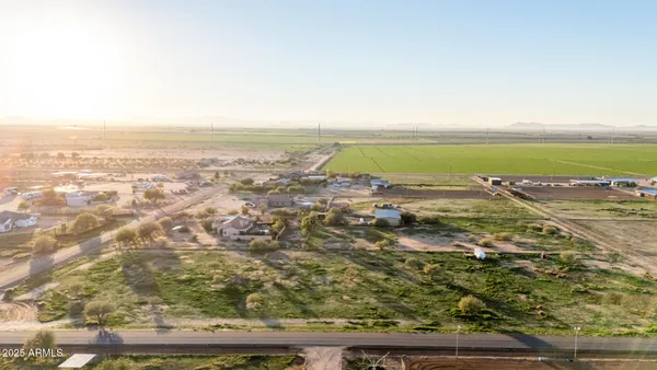 an aerial view of ocean and residential houses with outdoor space