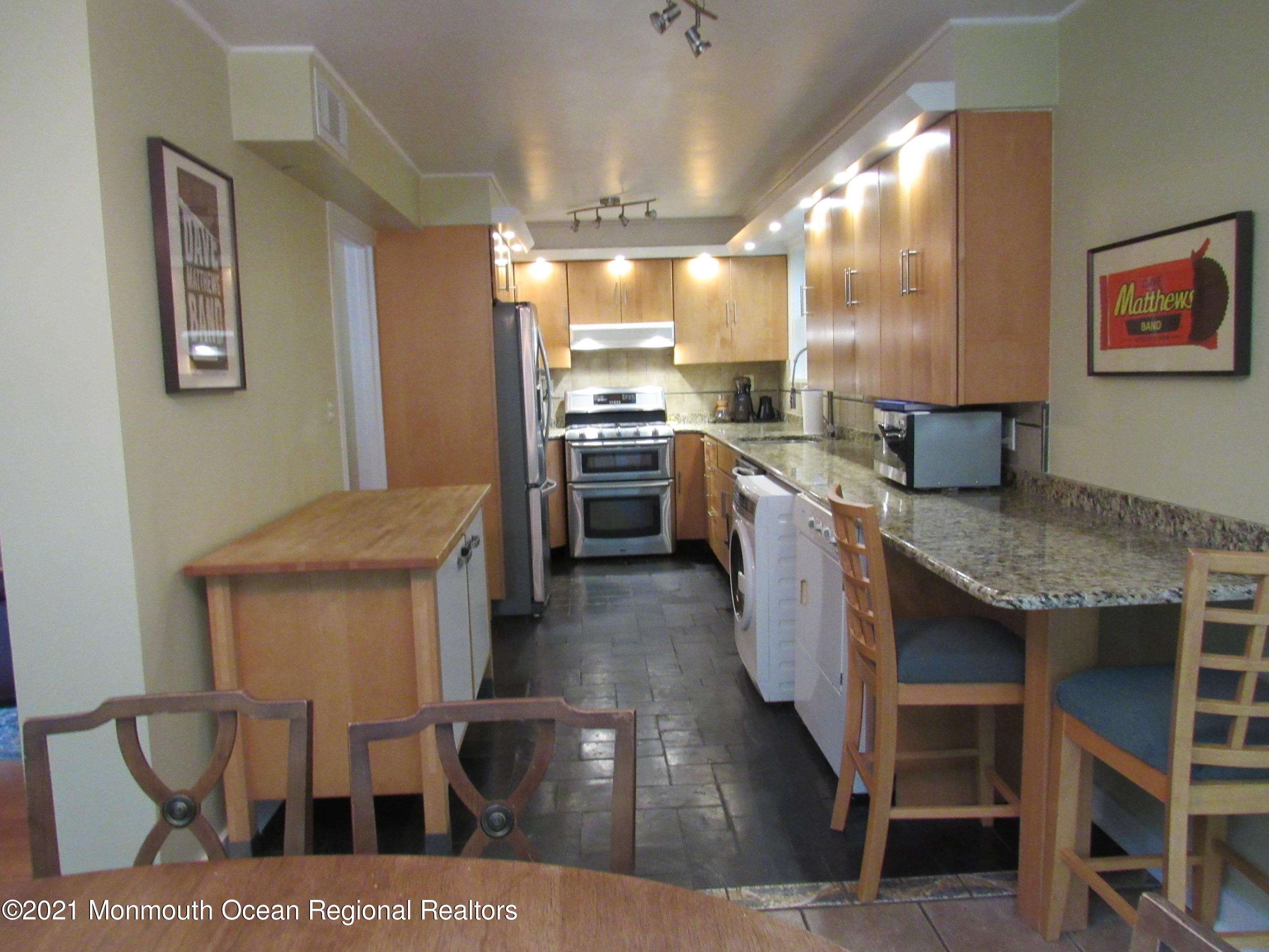 17 Pine Drive Roosevelt, NJ 08555 - Photo 13 of 22 a kitchen with stainless steel appliances kitchen island granite countertop a table chairs and a refrigerator