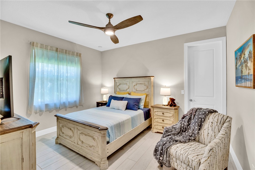 105 Night Hawk Way Sebastian, FL 32958 - Photo 24 of 36 a bedroom with furniture and a chandelier