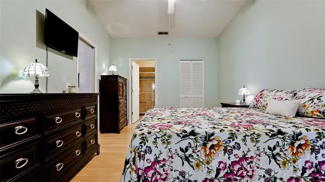 a bedroom with a bed and flat tv screen on the dresser