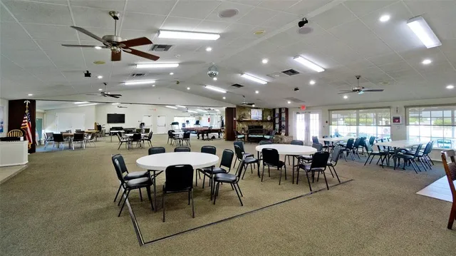 a very nice looking dining room with stainless steel appliances a table and chairs