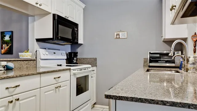 a kitchen with stainless steel appliances granite countertop a sink and a stove