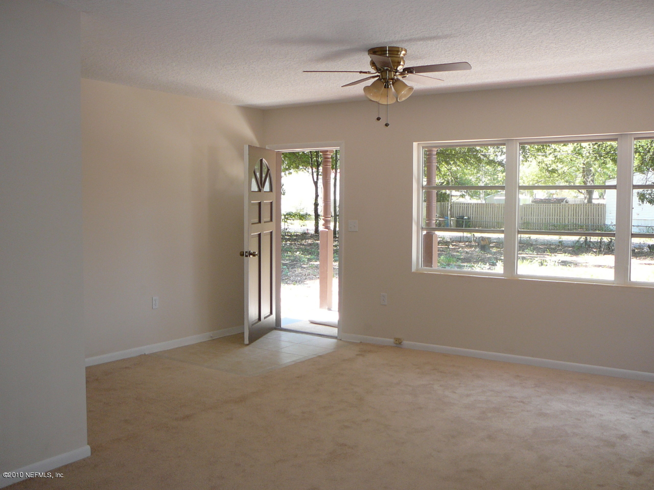 437 Jackson Road Jacksonville, FL 32225 - Photo 6 of 24 an empty room with windows and ceiling fan