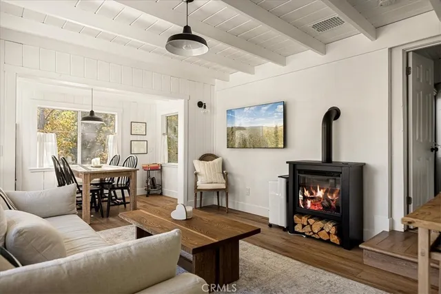 a living room with furniture a fireplace and a dining table with wooden floor