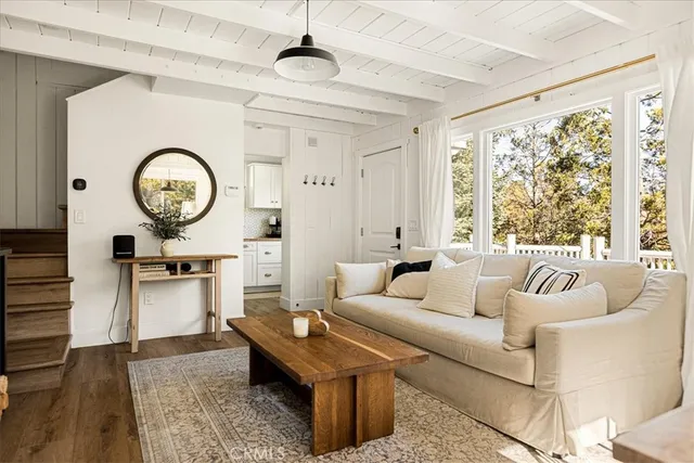 a living room with furniture a clock and a large window