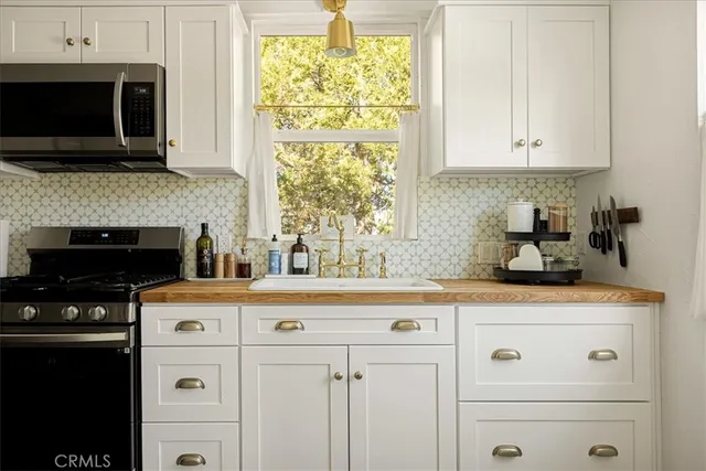 a kitchen with granite countertop white cabinets and black appliances