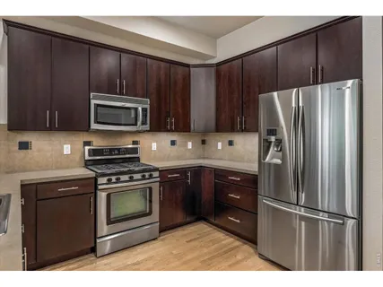 a kitchen with granite countertop wooden cabinets and stainless steel appliances