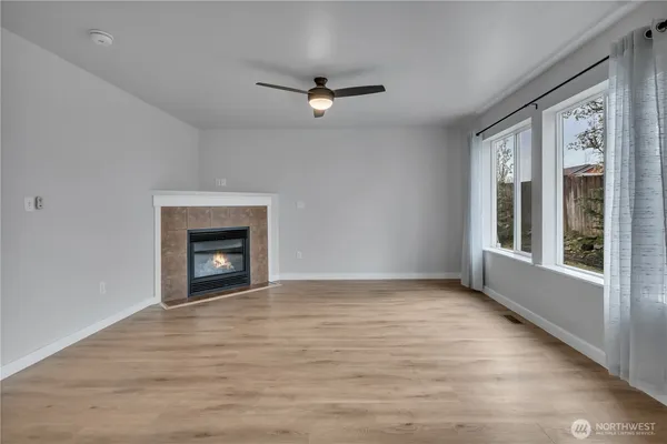 a view of an empty room with a window and fireplace