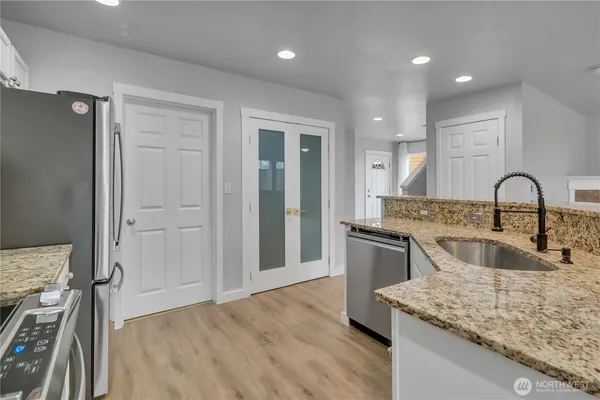 a kitchen with a sink and a stove top oven with wooden floor