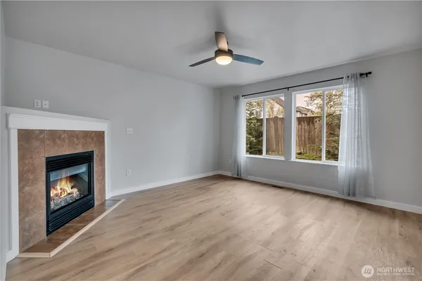 a view of an empty room with window and fire place