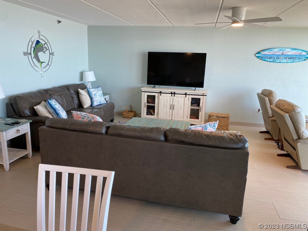 6727 Turtlemound Road, Unit 416 New Smyrna Beach, FL 32169 - Photo 11 of 67 a living room with furniture and a flat screen tv