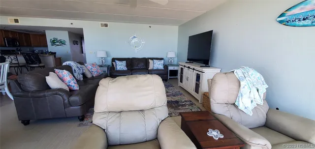 a dining room with furniture and floor to ceiling window