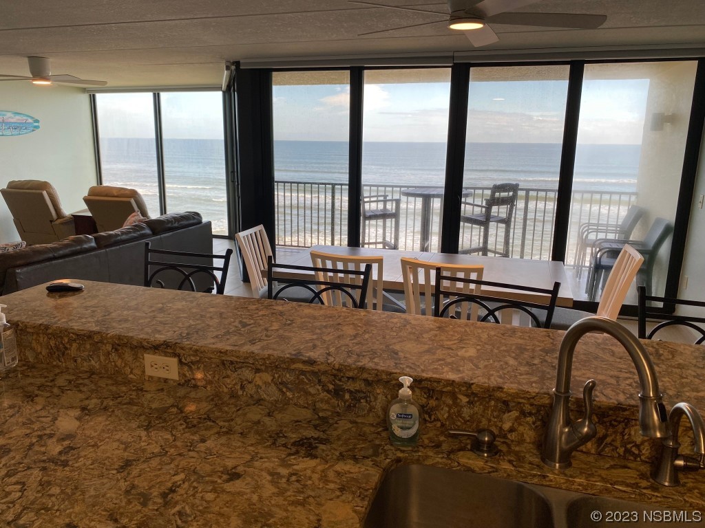 6727 Turtlemound Road, Unit 416 New Smyrna Beach, FL 32169 - Photo 17 of 67 a dining room with furniture and floor to ceiling window