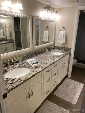a spacious bathroom with a granite countertop sink and a mirror