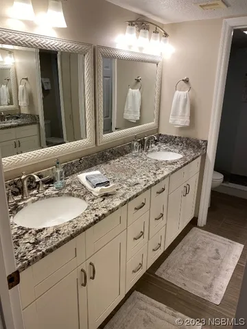 a spacious bathroom with a granite countertop sink and a mirror
