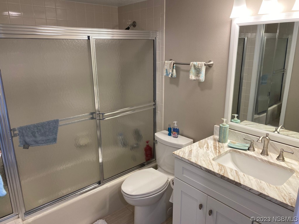 6727 Turtlemound Road, Unit 416 New Smyrna Beach, FL 32169 - Photo 38 of 67 a bathroom with a granite countertop sink toilet and shower