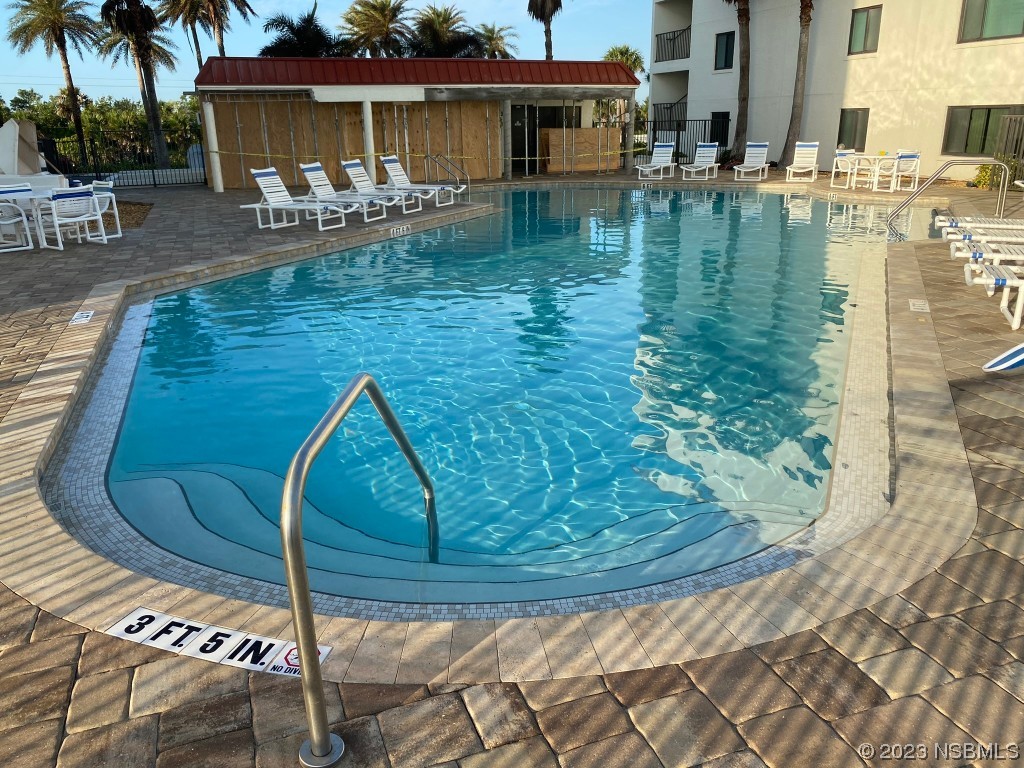 6727 Turtlemound Road, Unit 416 New Smyrna Beach, FL 32169 - Photo 55 of 67 a swimming pool with outdoor seating yard and barbeque oven