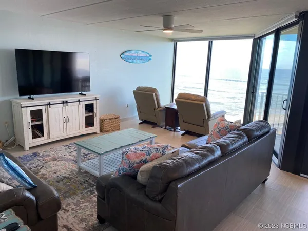 a dining room with furniture and large windows