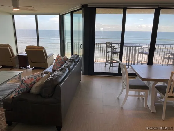 a living room with furniture and a floor to ceiling window