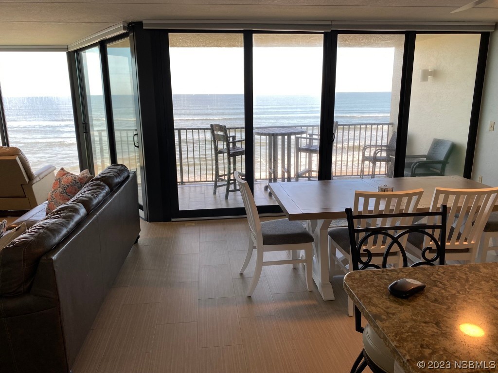 6727 Turtlemound Road, Unit 416 New Smyrna Beach, FL 32169 - Photo 8 of 67 a dining room with furniture and large windows