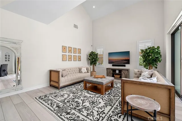 a living room with furniture a flat screen tv and a table