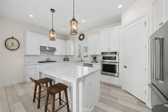 a kitchen with a stove cabinets and a wooden floor