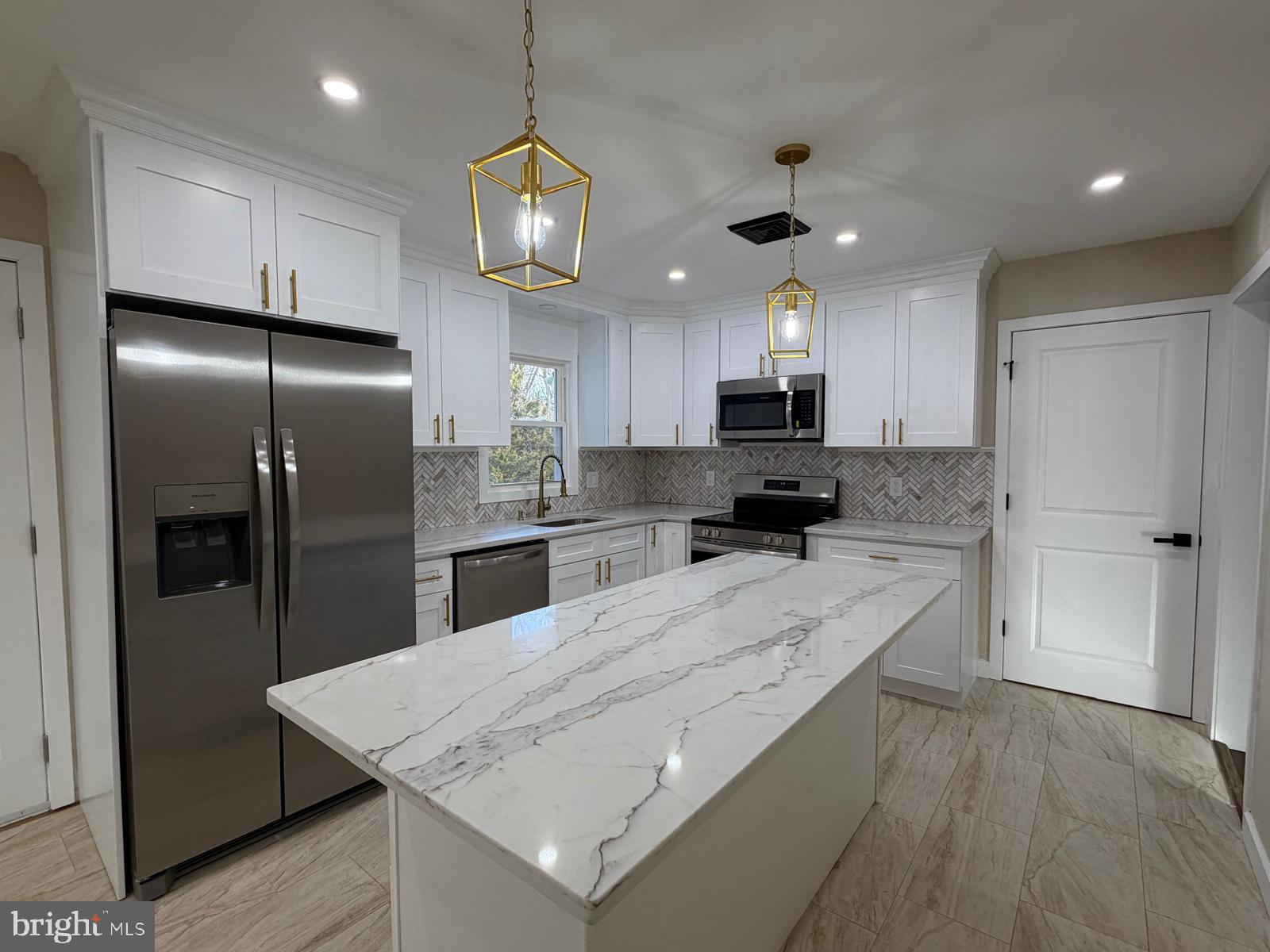 24 Rieck Avenue Millville, NJ 08332 - Photo 11 of 57 a kitchen with granite countertop a refrigerator a stove a sink and white cabinets with wooden floor