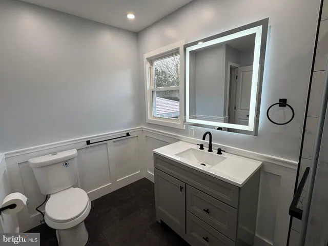 a bathroom with a sink toilet and window