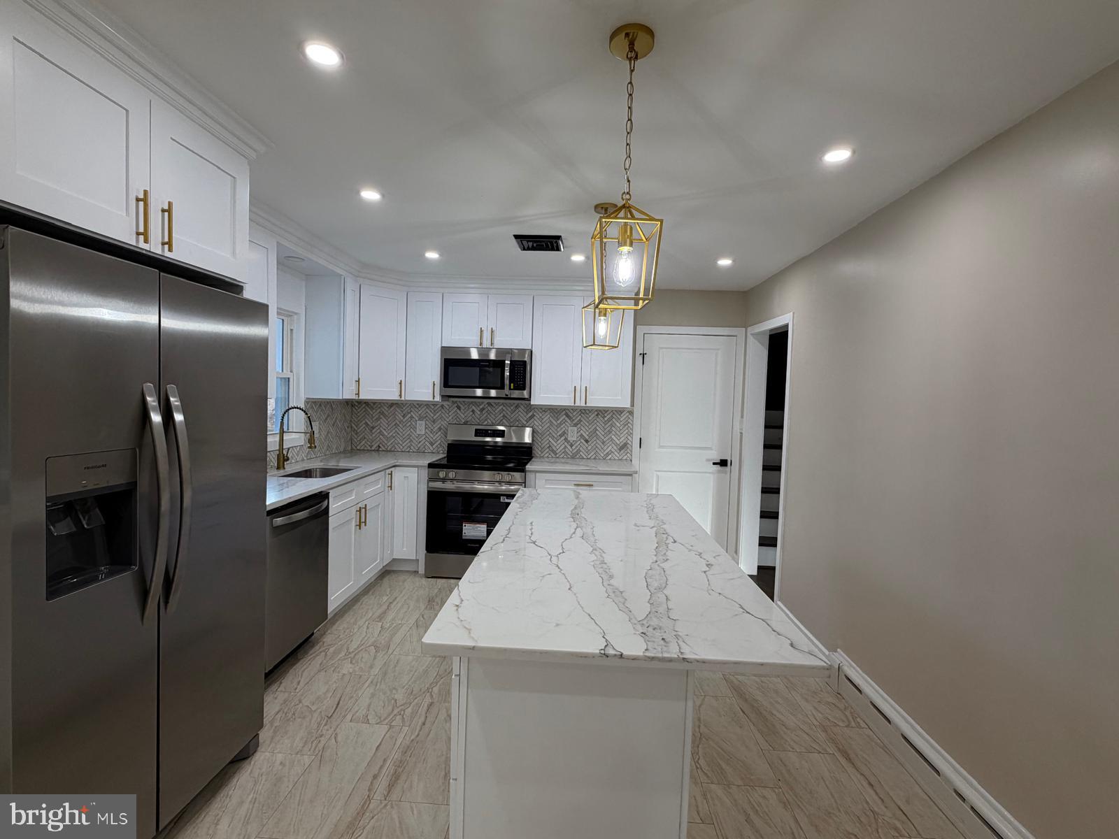 24 Rieck Avenue Millville, NJ 08332 - Photo 9 of 57 a kitchen with stainless steel appliances kitchen island granite countertop a refrigerator a stove and a sink with wooden floor