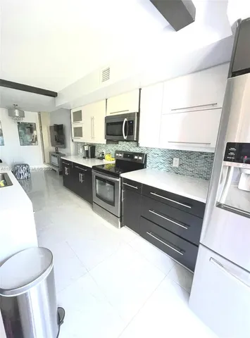 a kitchen with a stove a sink and a refrigerator