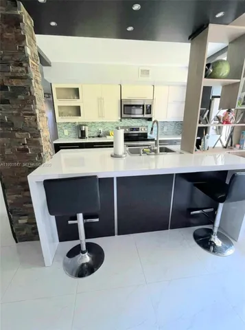 a kitchen with stainless steel appliances kitchen island granite countertop a sink and a stove