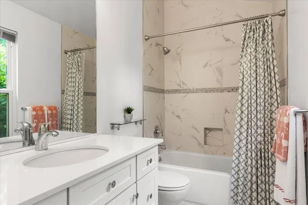 a bathroom with a granite countertop shower a sink and a mirror