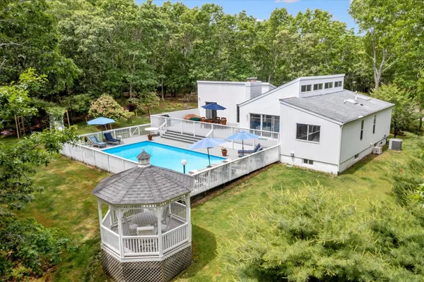 a view of a house with pool and chairs