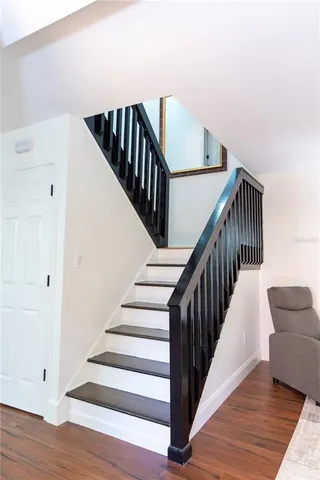 a view of staircase with wooden floor and white walls