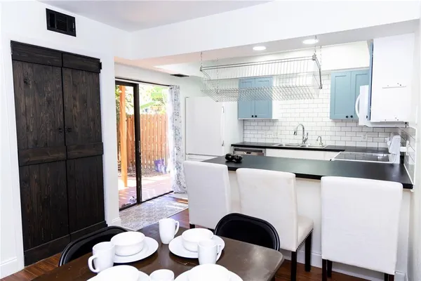 a kitchen with a table chairs sink and cabinets