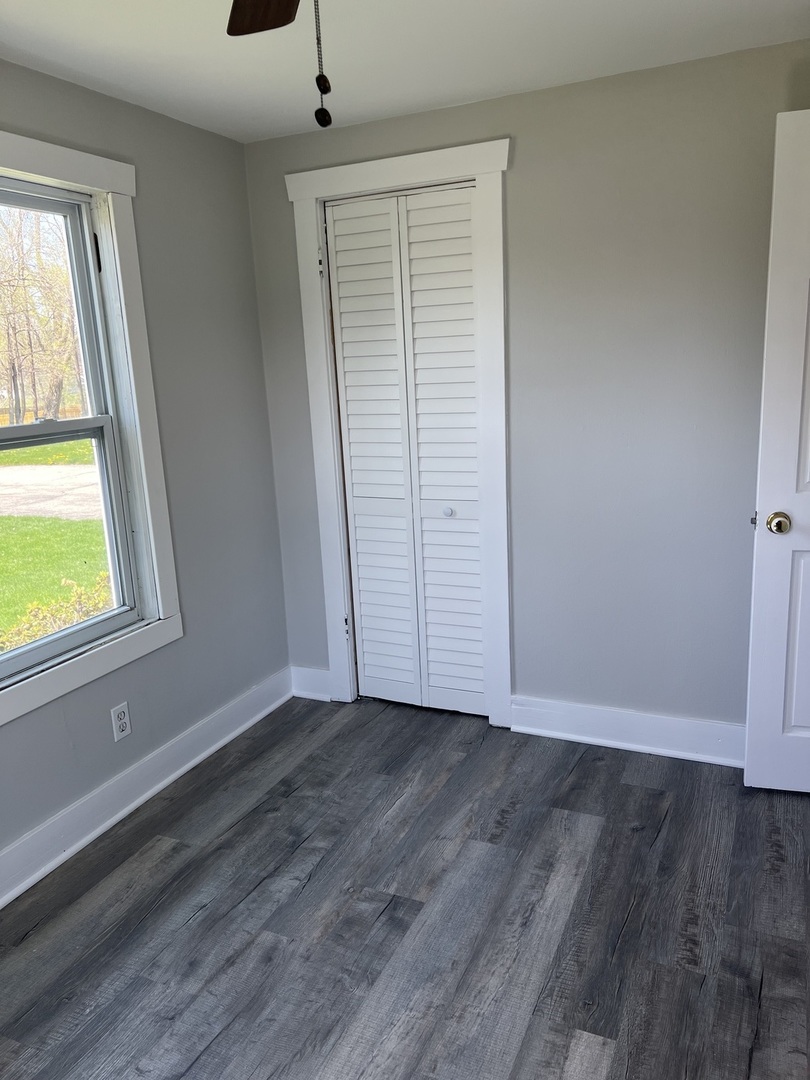 207 Second Street Elgin, IL 60123 - Photo 17 of 23 an empty room with wooden floor cabinet and windows
