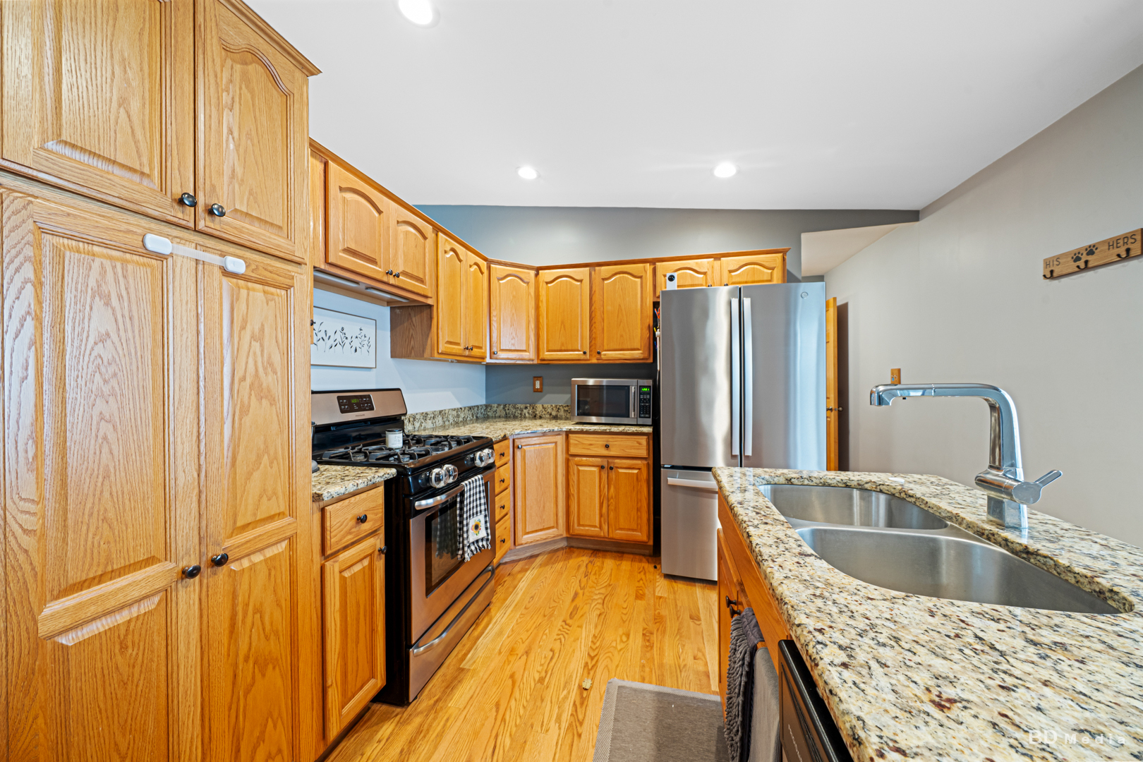 709 Cascade Avenue Romeoville, IL 60446 - Photo 8 of 23 a kitchen with stainless steel appliances granite countertop a refrigerator a sink dishwasher a stove and white countertops with wooden floor