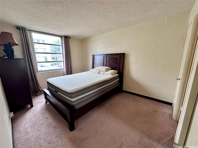a bed sitting in a bedroom next to a window