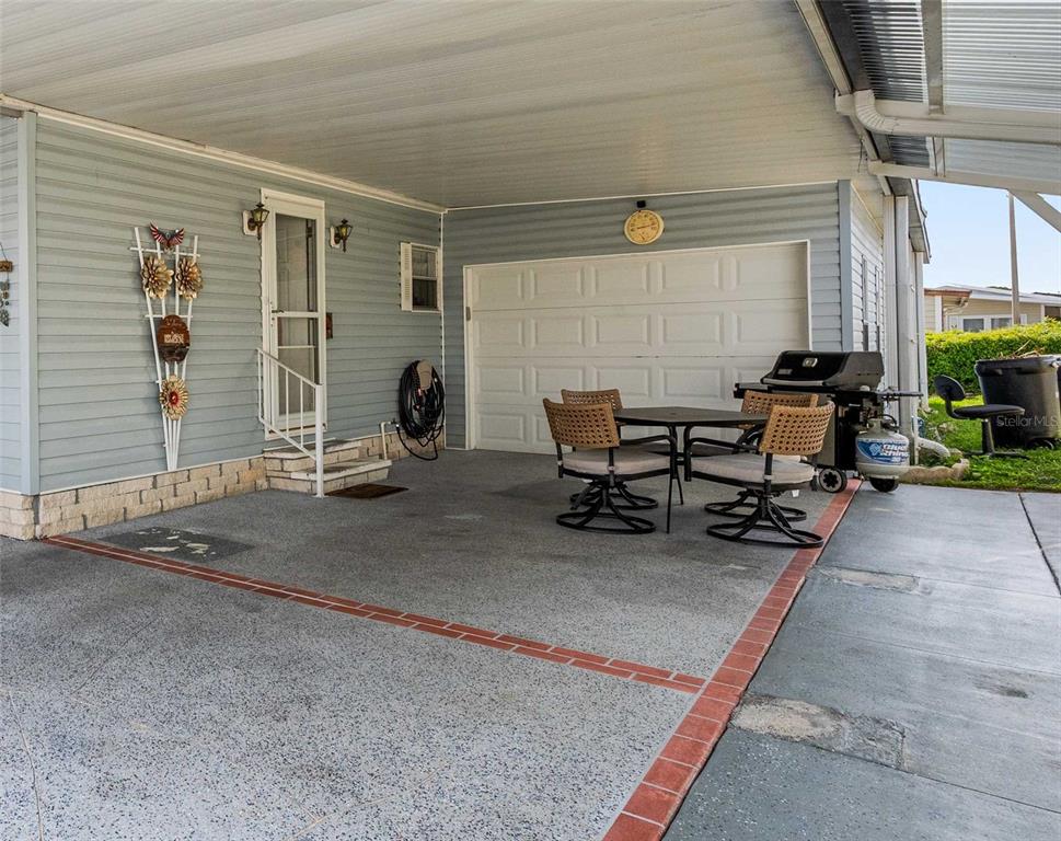 7135 El Dewitt Street Zephyrhills, FL 33541 - Photo 21 of 46 a view of a patio with table and chairs and potted plants