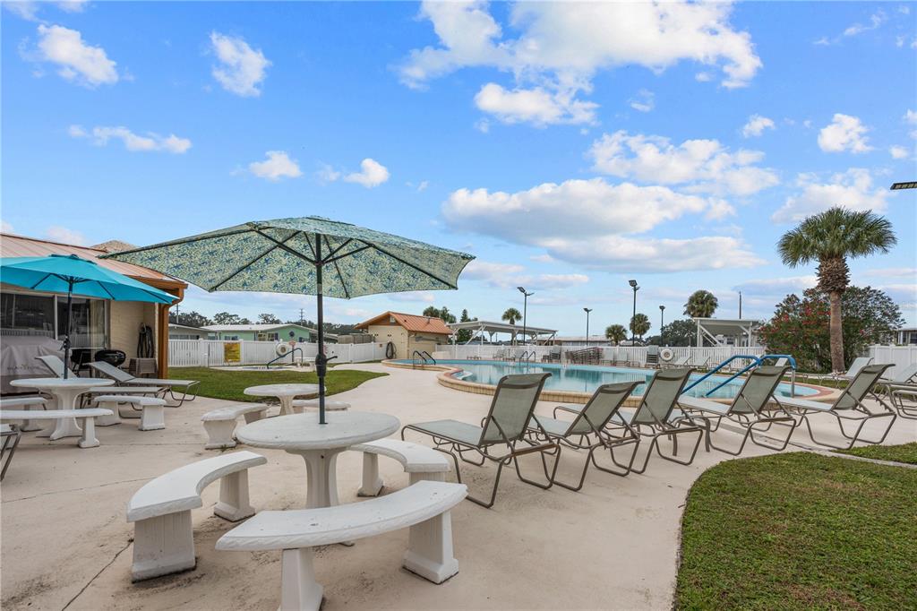 7135 El Dewitt Street Zephyrhills, FL 33541 - Photo 35 of 46 a view of a patio with dining table and chairs under an umbrella